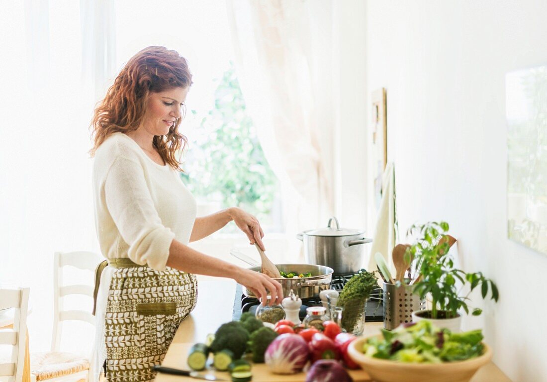 Germany, Bavaria, Munich, Woman preparing food in kitchen