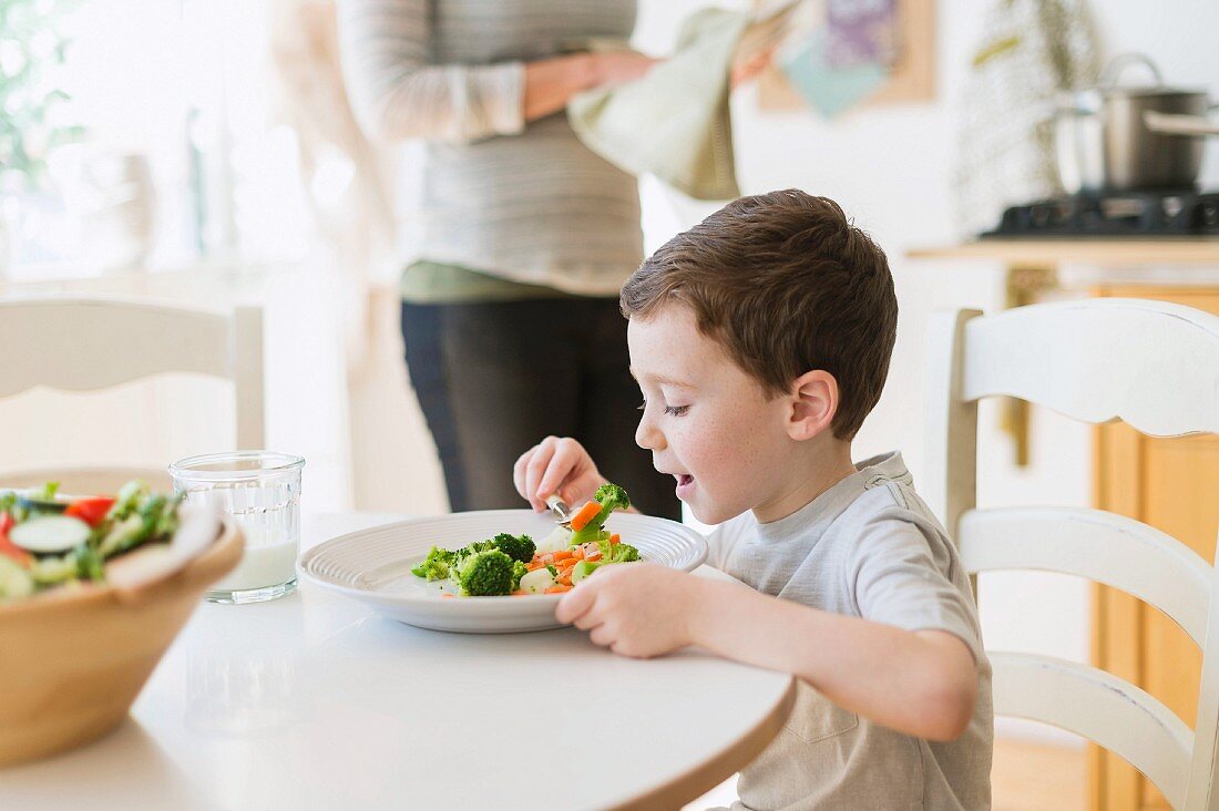 A little boy eating vegetables