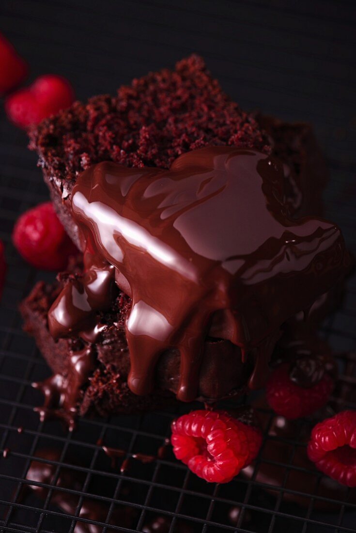 Schokoladenkuchen mit Schokoglasur und frischen Himbeeren