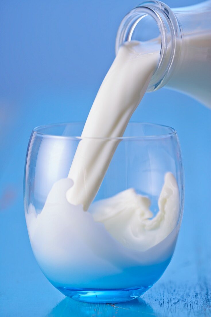 Milk Pouring From a Bottle into a Glass