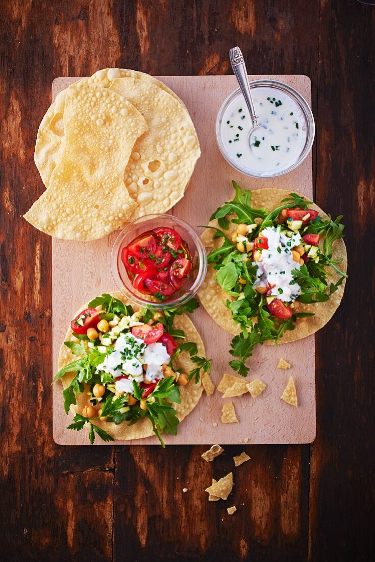 Poppadoms served with a tomato and chickpea salad and yogurt