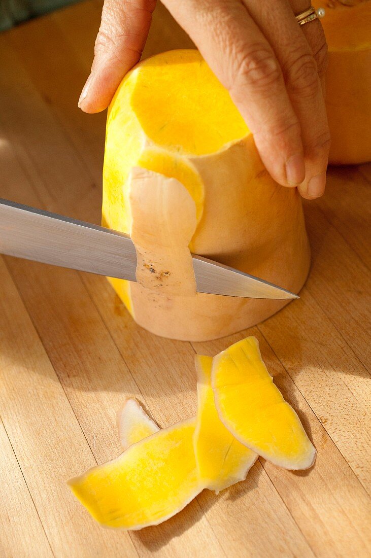 A butternut squash being peeled