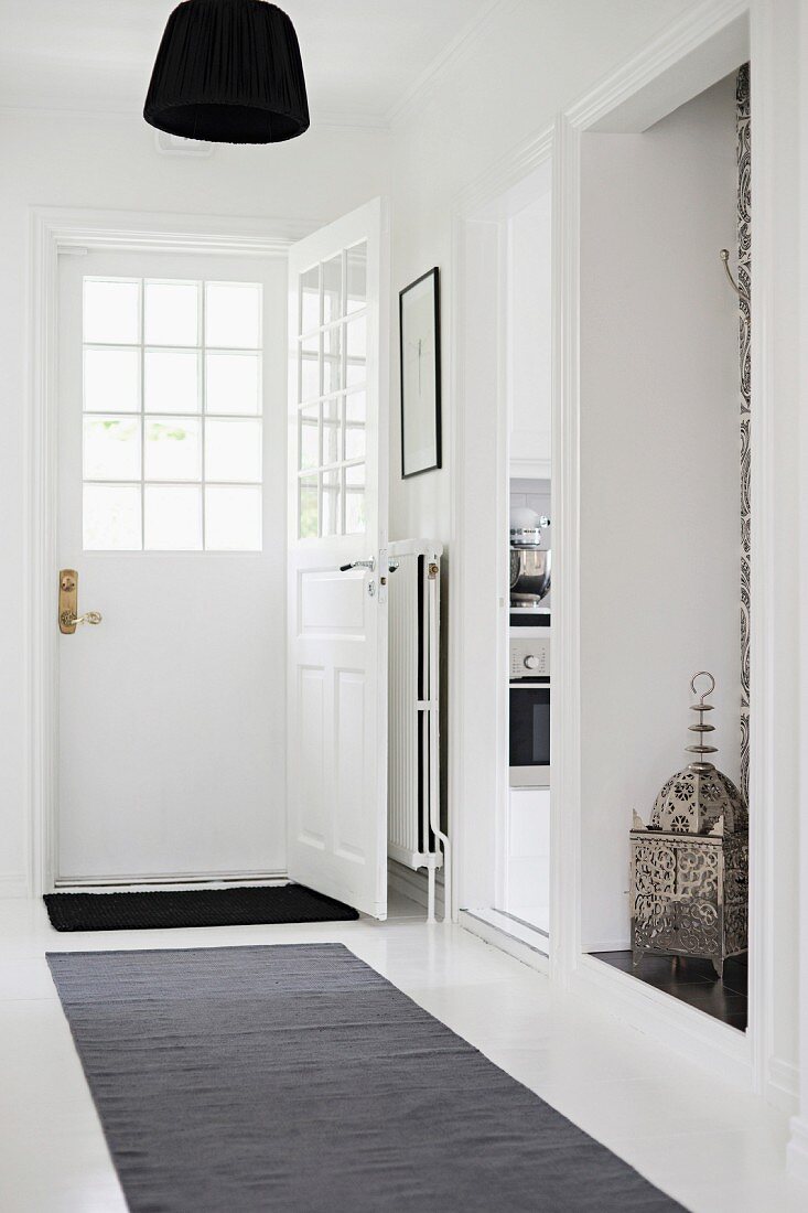 White hallway with black lampshade, dark grey runner and Oriental lantern