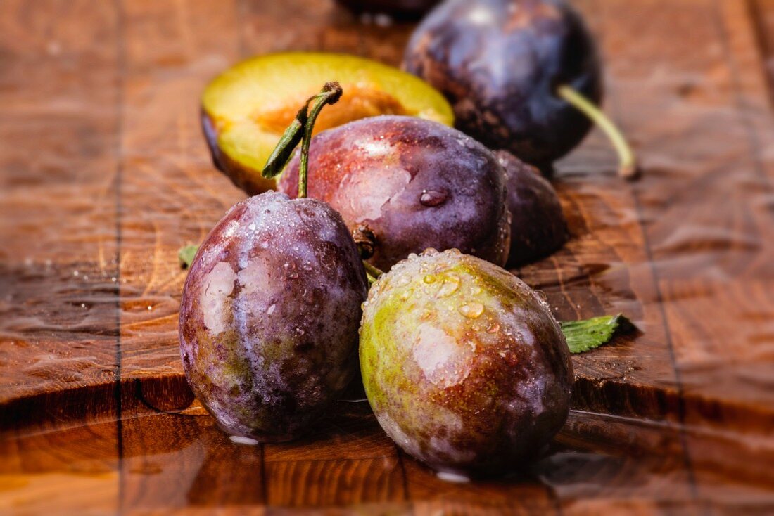 Freshly washed plums on a wooden board