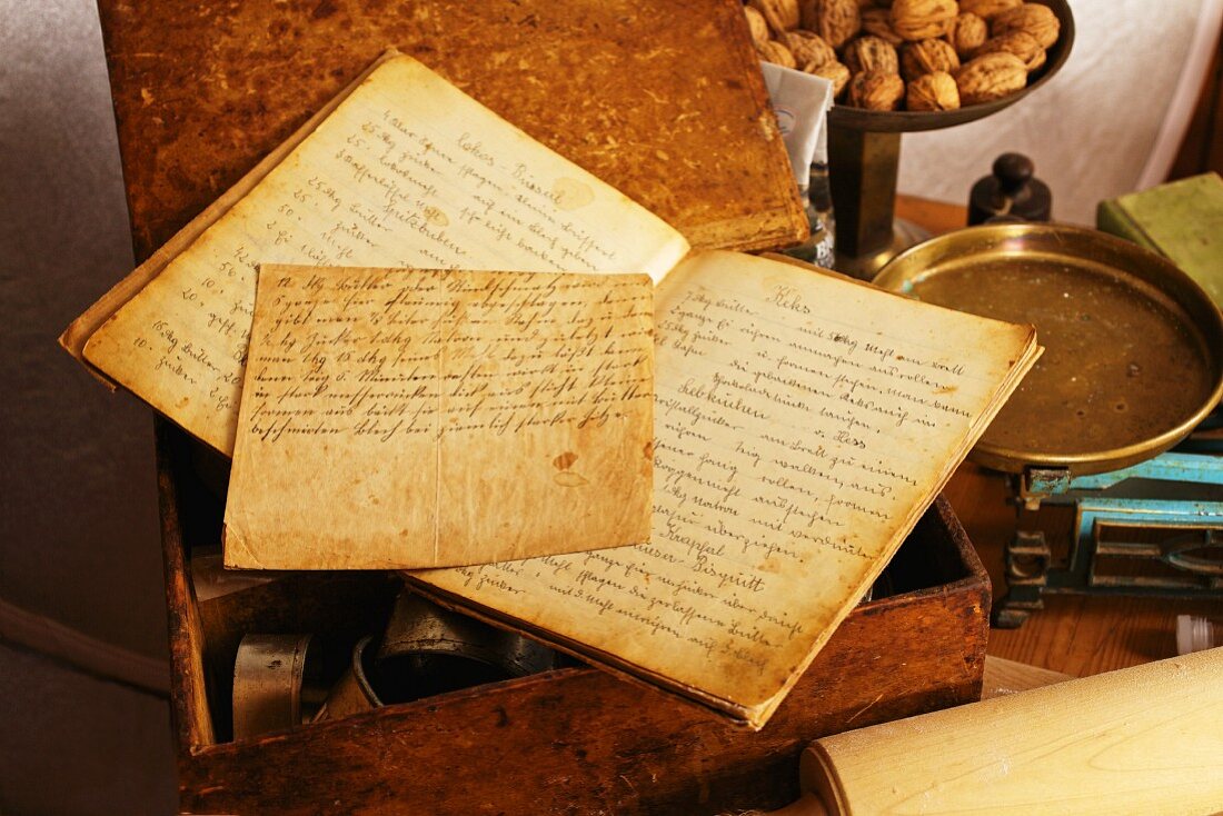 Altes handgeschriebenes Backbuch mit Waage und Walnüssen