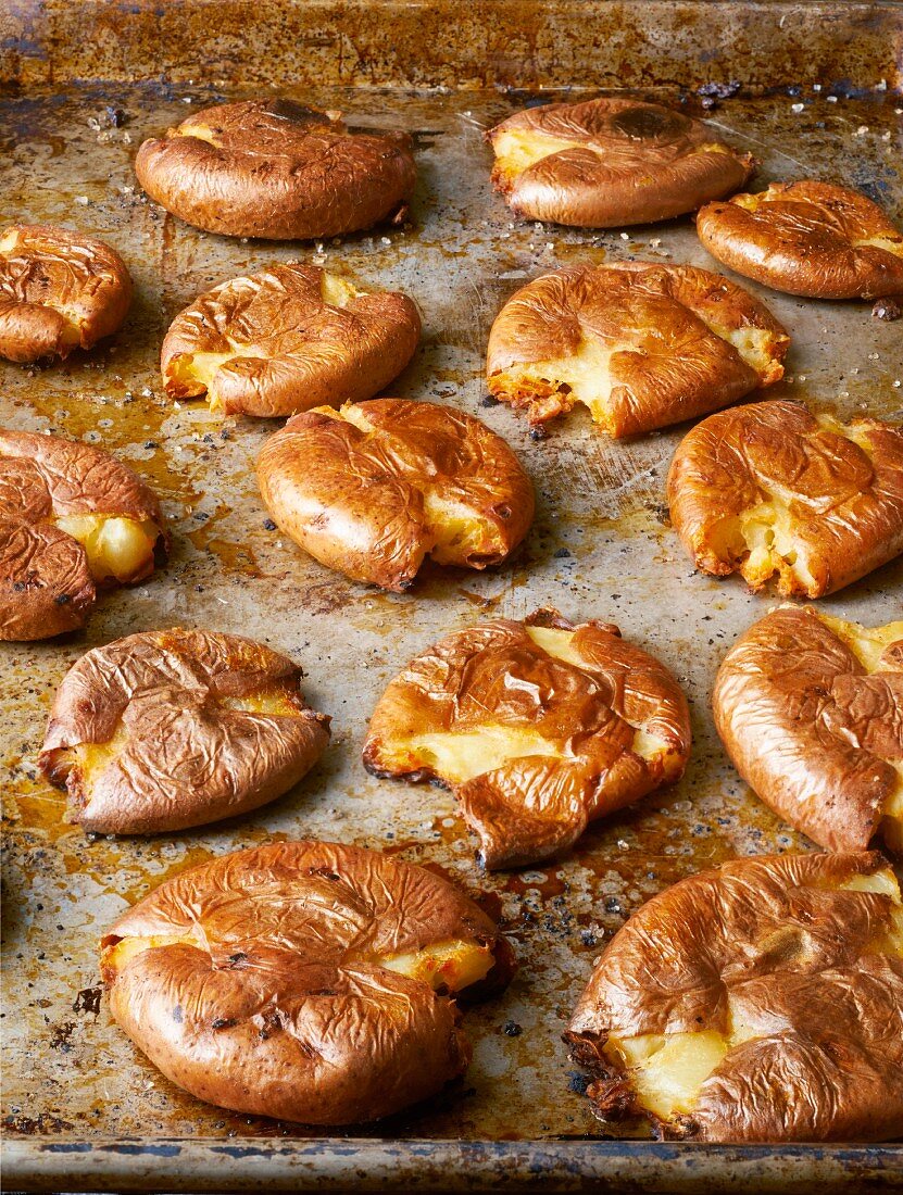 Squashed potatoes on a baking tray