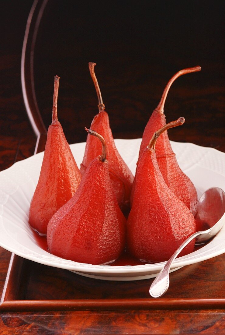 Red wine pears standing on a white plate