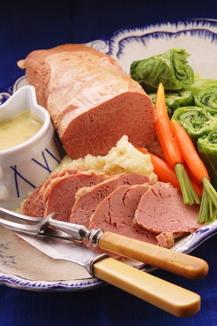 Traditional corned beef on a platter with mashed potatoes and vegetables