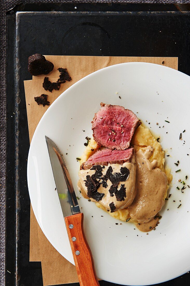 Beef fillet with a truffle sauce on a bed of mashed potatoes