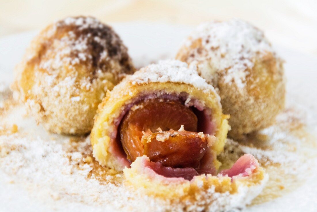 Damson dumplings with buttered crumbs and sugar on a plate