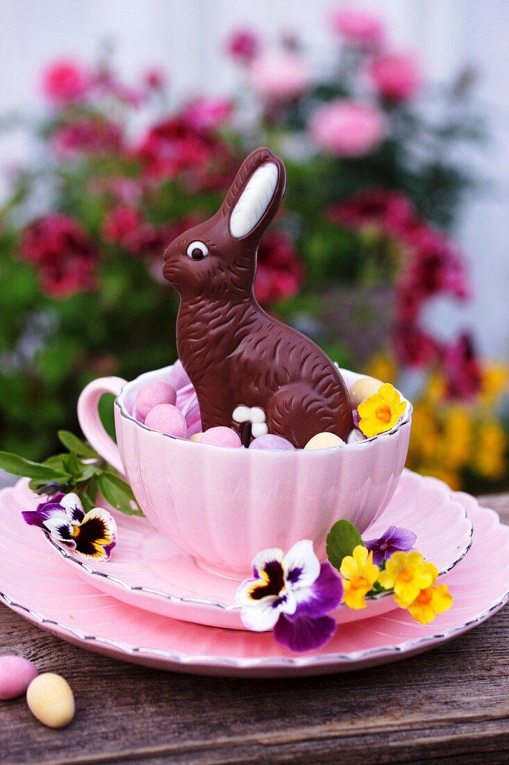 A place setting decorated with a chocolate Easter bunny, flowers and sugared eggs