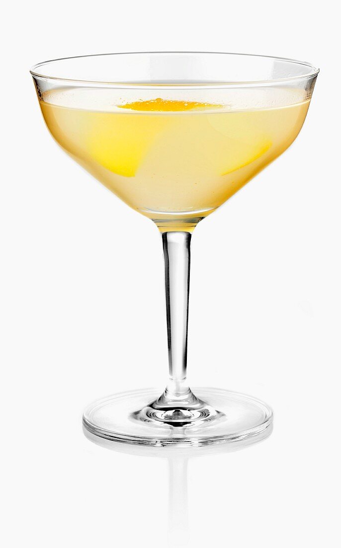A peach cocktail garnished with lemon zest