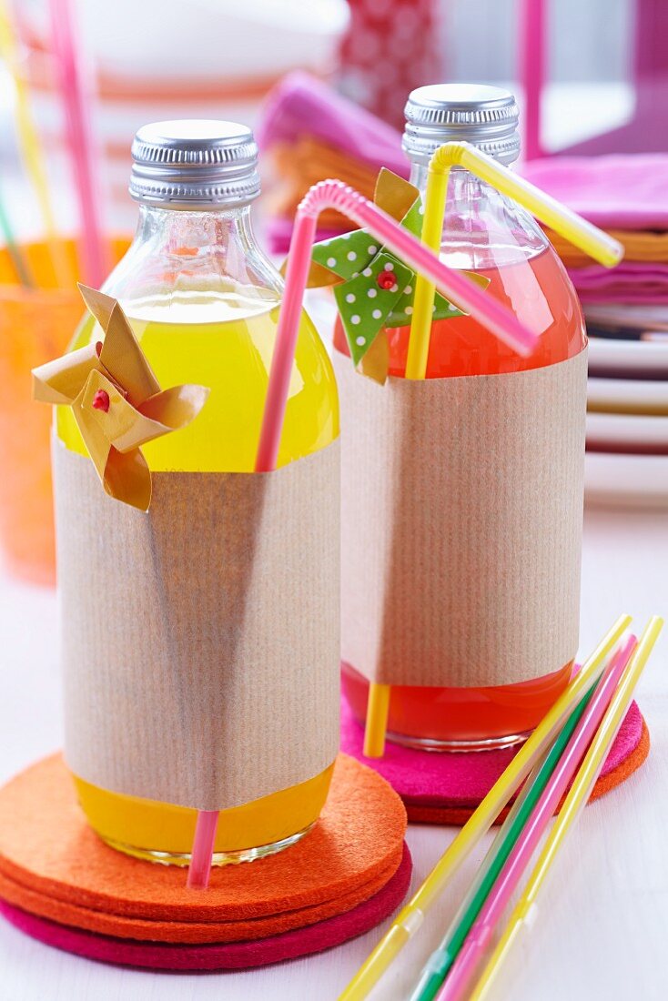 Bottles of pop decoratively wrapped in brown paper on felt coasters