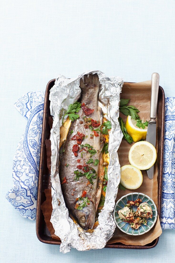 Baked trout with herbs and dried tomato butter