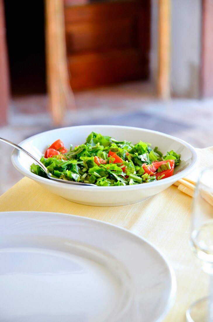 Gehackter Rucola-Tomaten-Salat auf einem Restauranttisch (Italien)