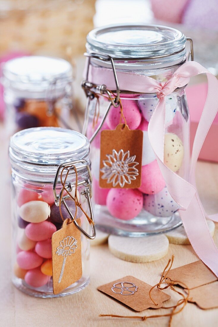 Easter eggs in preserving jars decorated with ribbons and paper tags