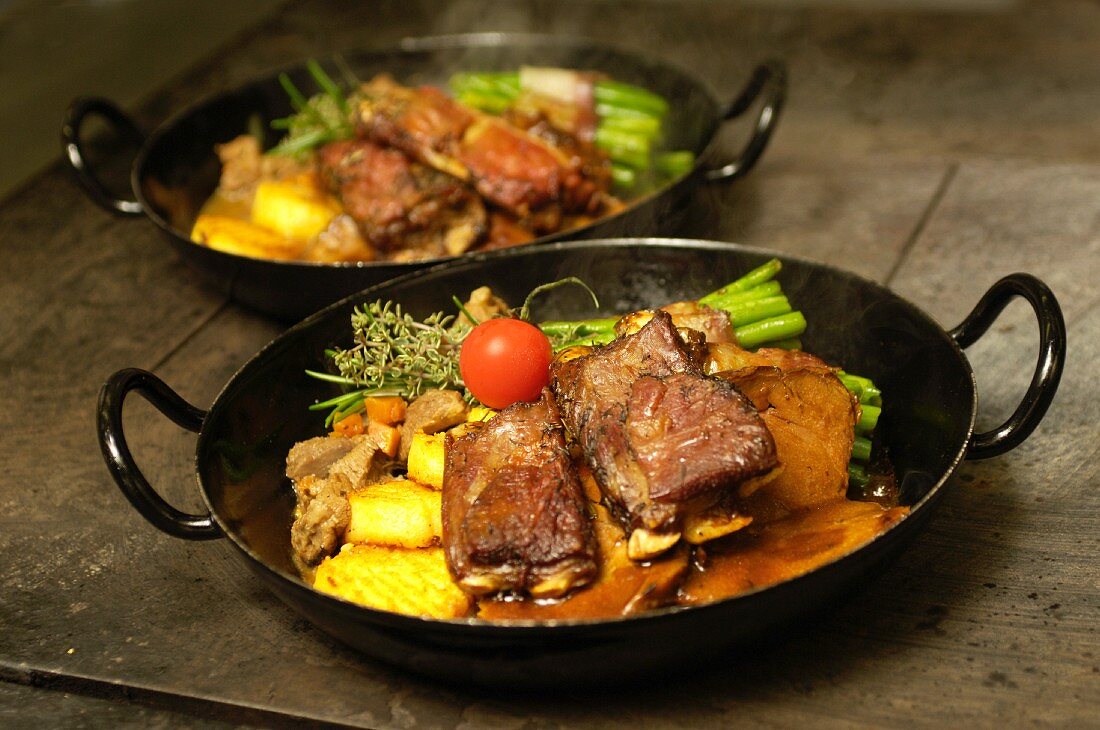 Leg of lamb and lamb ribs in a thyme sauce, and lamb ragout with bacon beans and polenta, East Tyrol, Austria