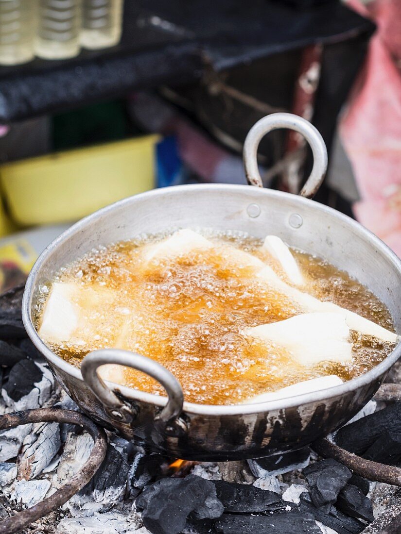 Frittierte Cassave in heißem Öl auf einem Markt in Sansibar