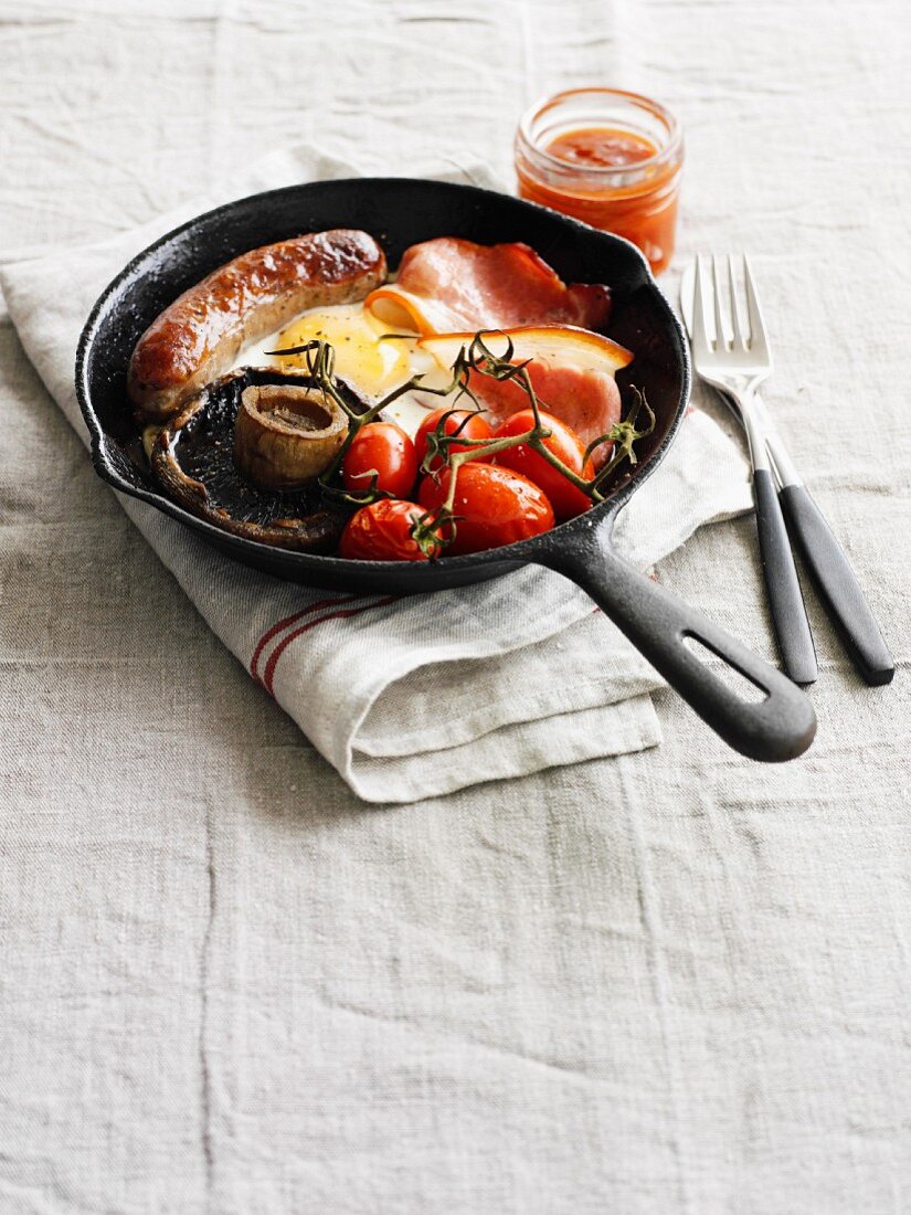 Englisches Frühstück mit Bacon, Würstchen, Schinken, Pilz und Tomaten