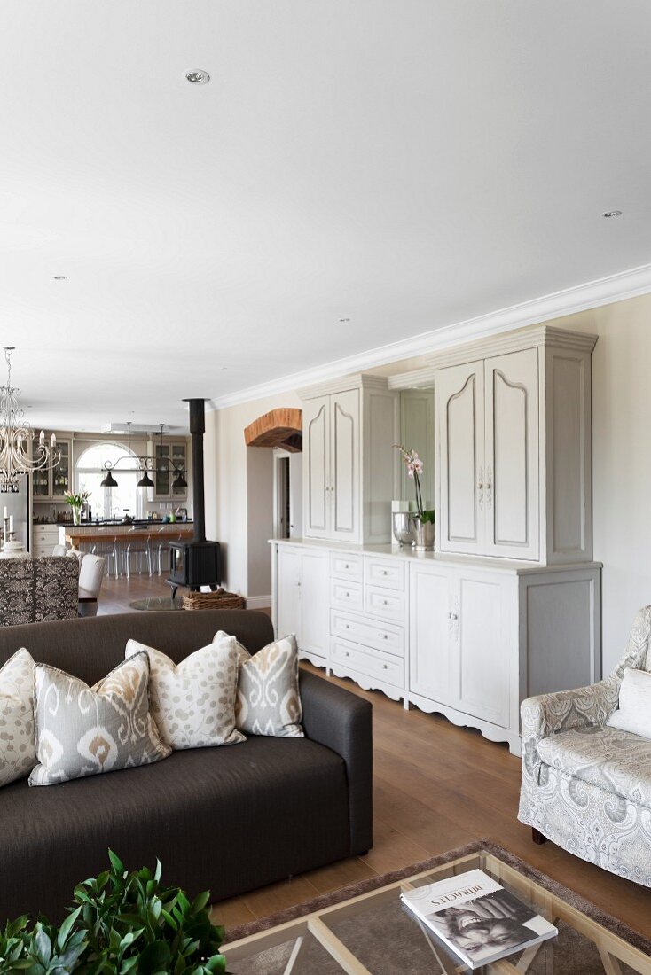 weiße Anrichte im eleganten Landhausstil zwischen Sitzbereich und Essplatz in offenem Wohnraum