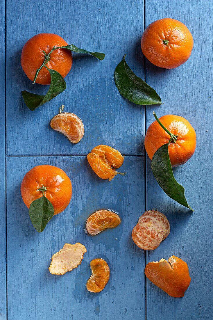 Clementinen mit Blättern, ganz und geschält
