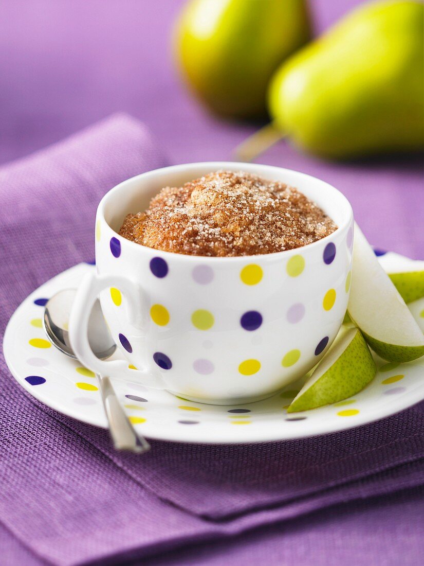 A muffin with cinnamon sugar and pears in a cup