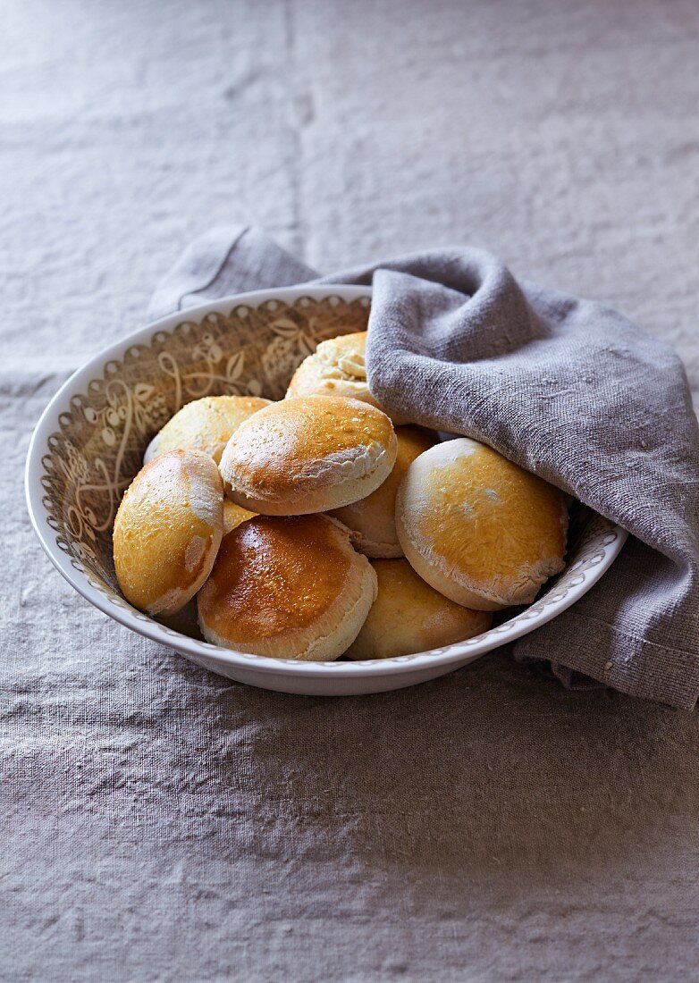 Rustikale hausgemachte Scones in einer Schüssel mit Tuch