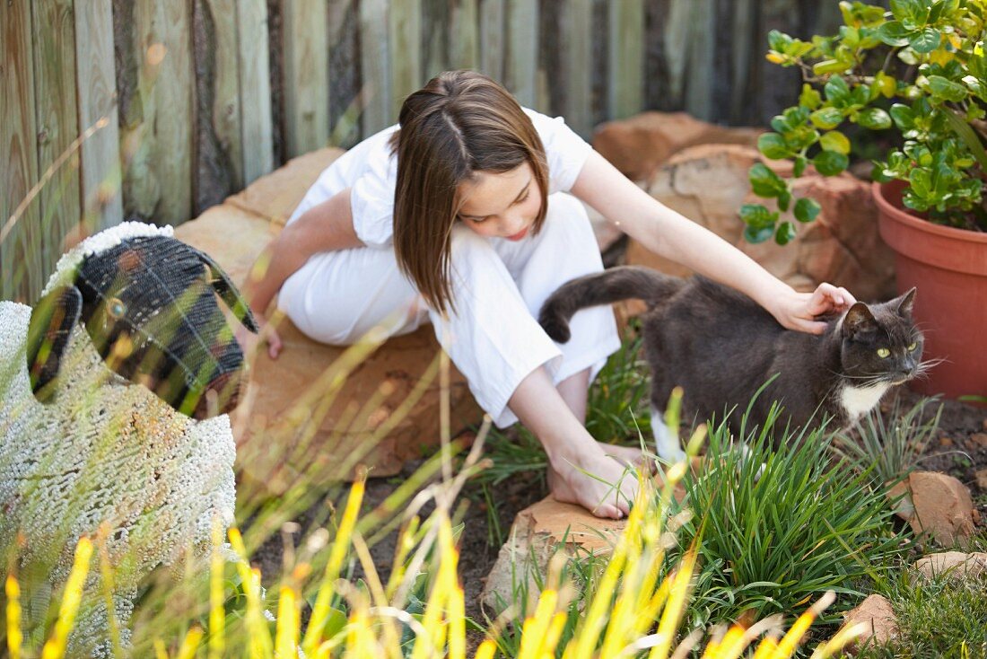 Mädchen mit Katze im Garten