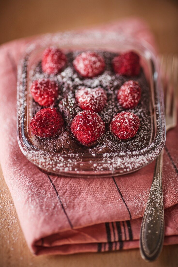 Schokoladenkuchen mit Himbeeren und Puderzucker