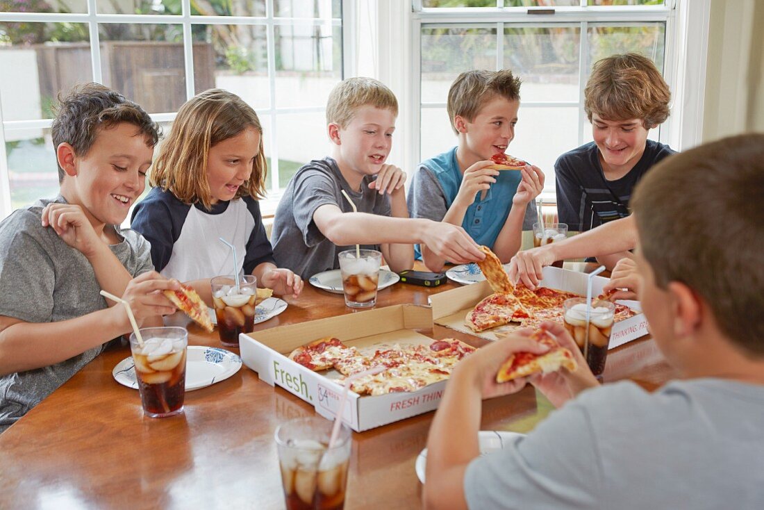 A group of boys sharing a pizza