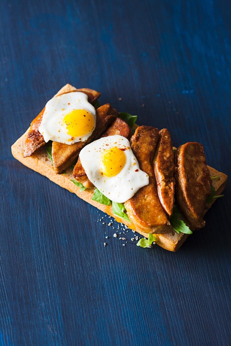 Bruschetta topped with goose liver and fried eggs