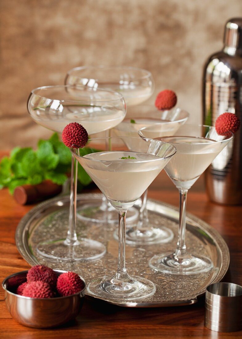 Ein Tablett mit Litschi-Minz-Martinis, garniert mit frischen Lychees