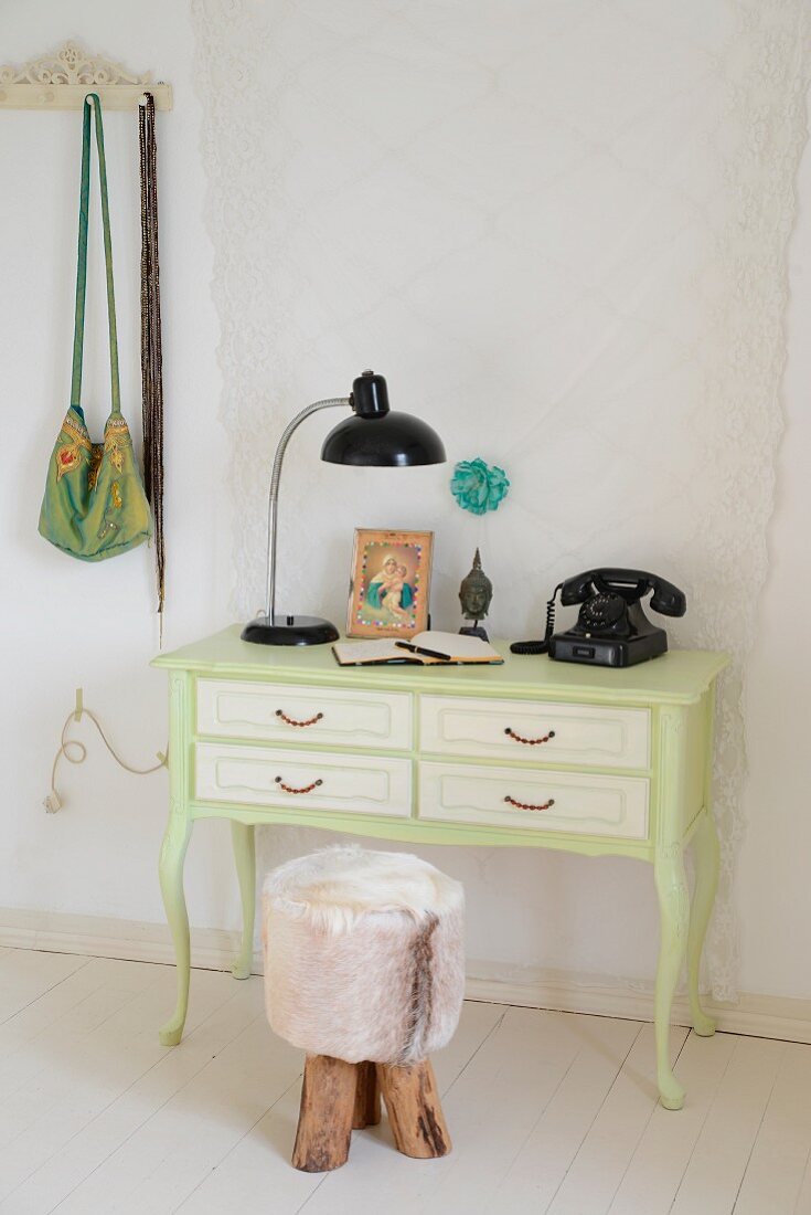 Miniature desk - writing desk painted pale green with vintage telephone, table lamp and rustic stool with fur cover on white board floor