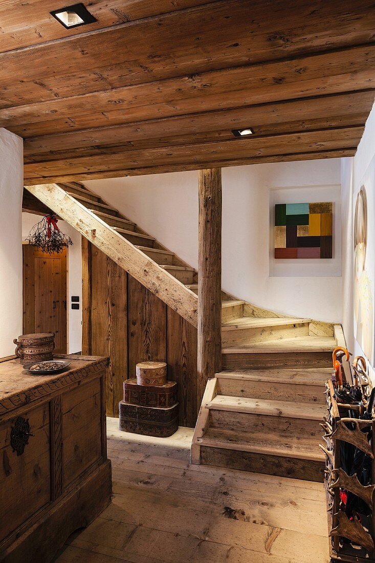 Holzstiege und antikes Dielenmobiliar in historischem, restauriertem Bauernhaus