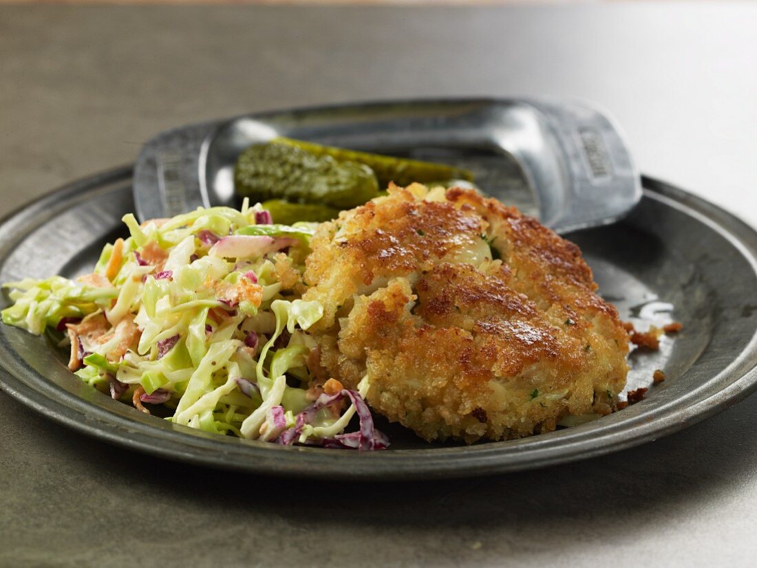 Crab cake with coleslaw and gherkins