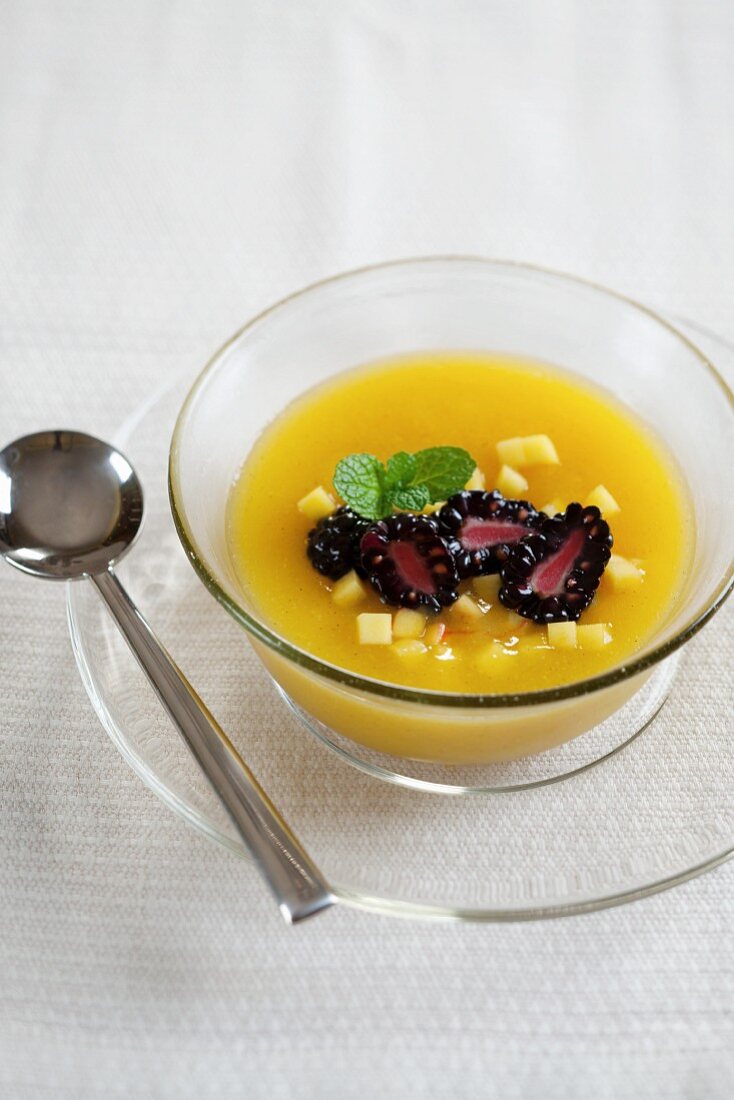 Cold mango soup with blackberries and mint