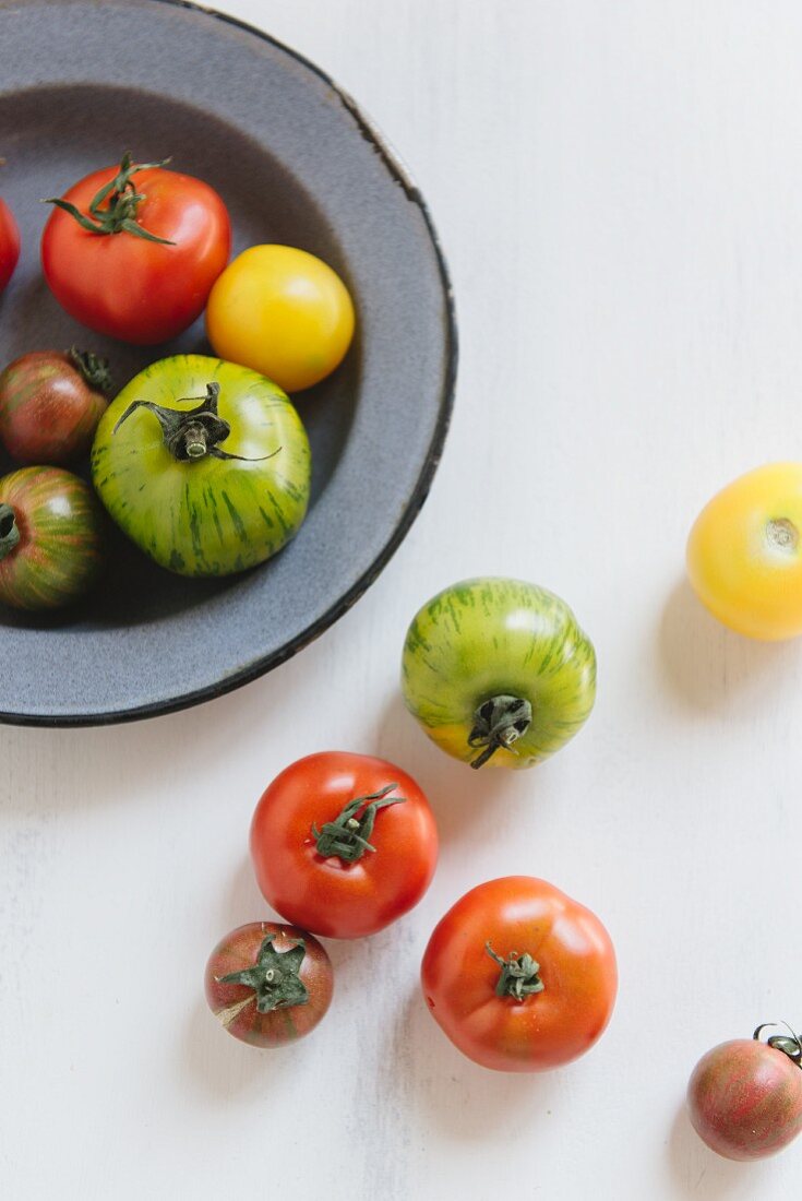 Various tomatoes on a plate and next to it