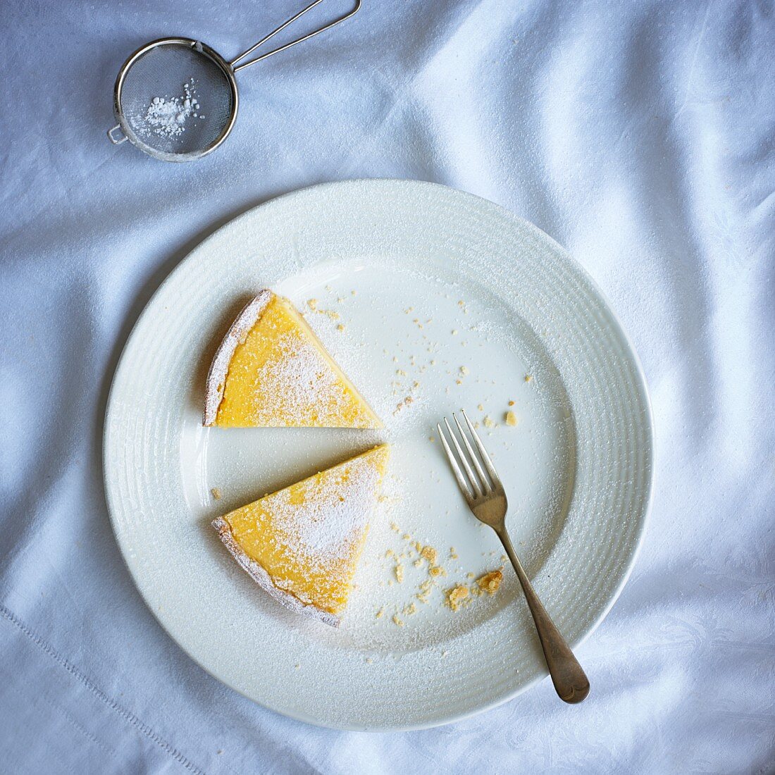 Two slices of lemon tart with icing sugar (seen from above)