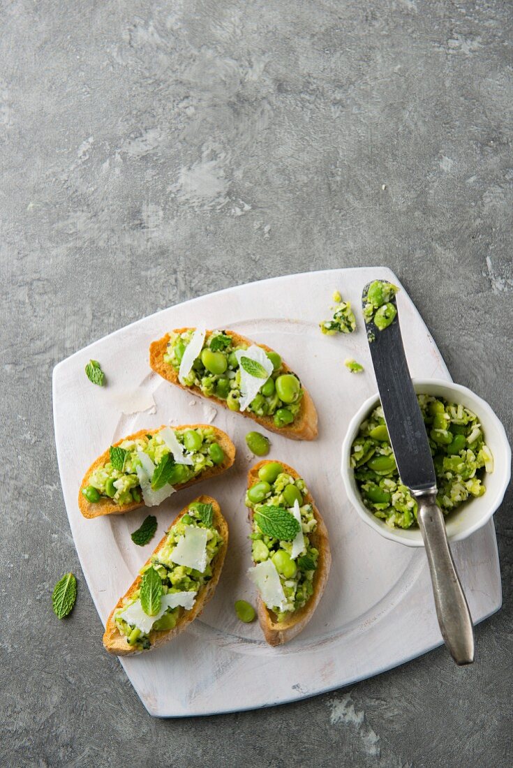 Crostini topped with broad beans, mint and Parmesan