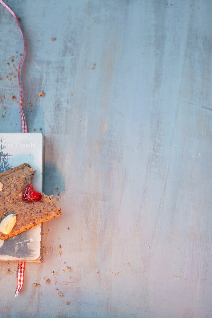 A gingerbread biscuit with a bite taken out on a white wooden board