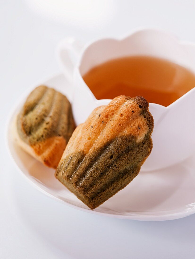 Bi-coloured tea madeleines on a saucer