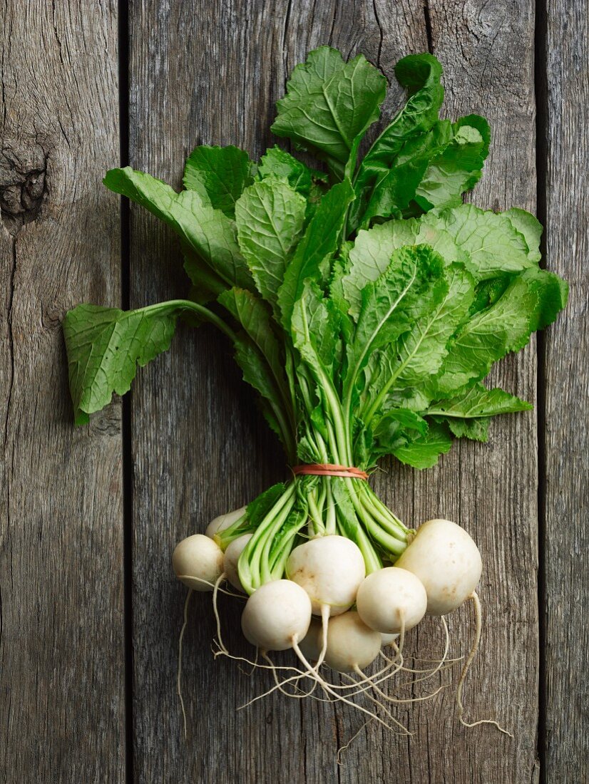 A bunch of white turnips on a wooden surface
