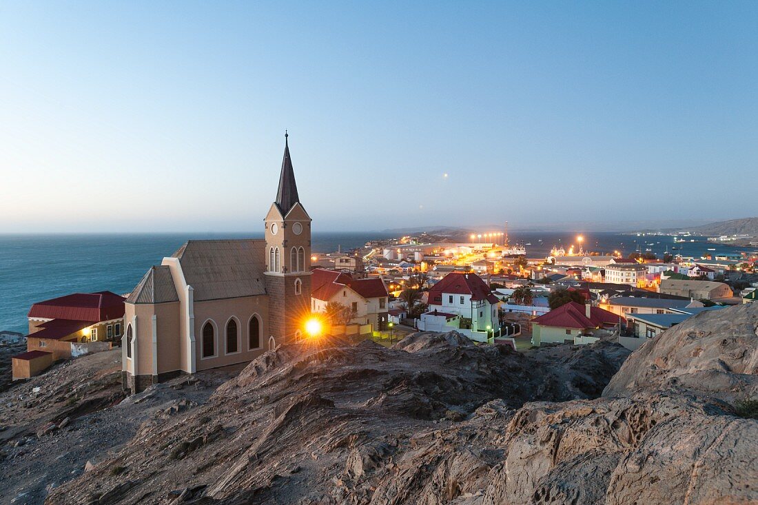 A view of the monolithic church and the illuminations in the harbour in Lüderitz, Namibia