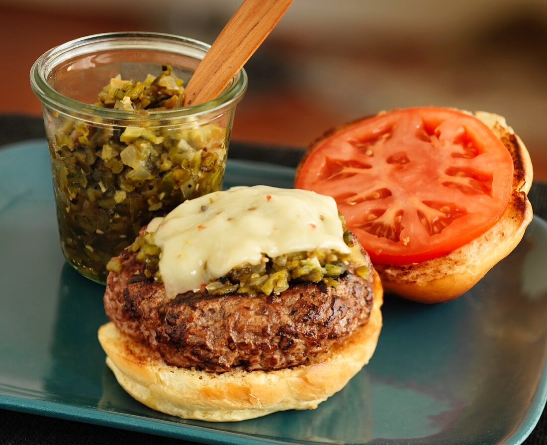 A cheeseburger with relish and tomatoes