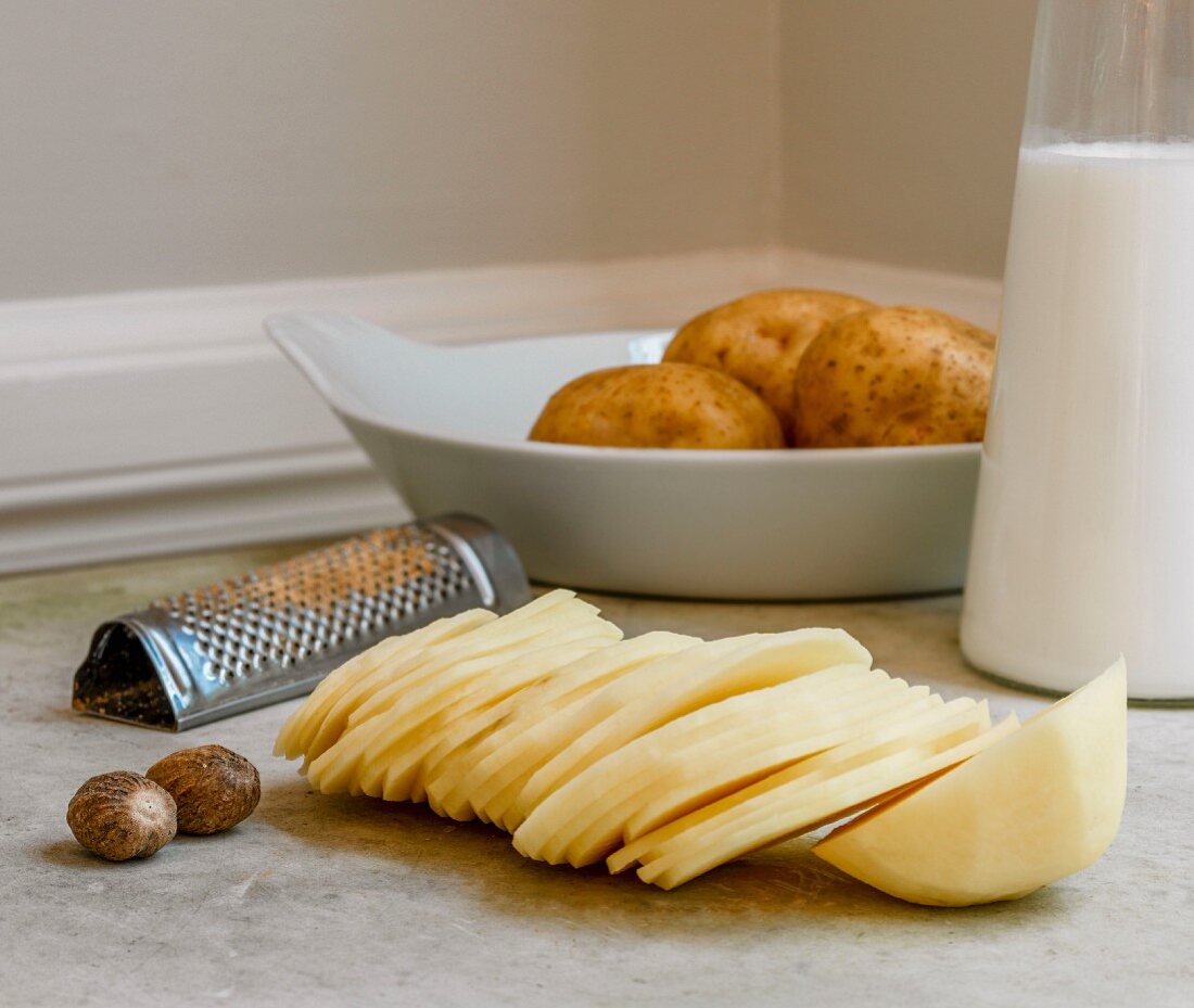 Zutaten für Kartofffelgratin: Kartoffelscheiben, Muskatnuss, Milch