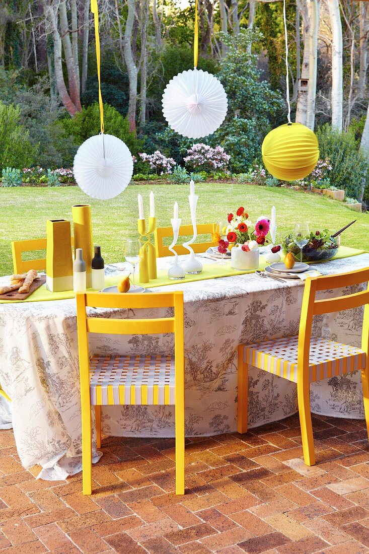 Festive terrace table below suspended lanterns