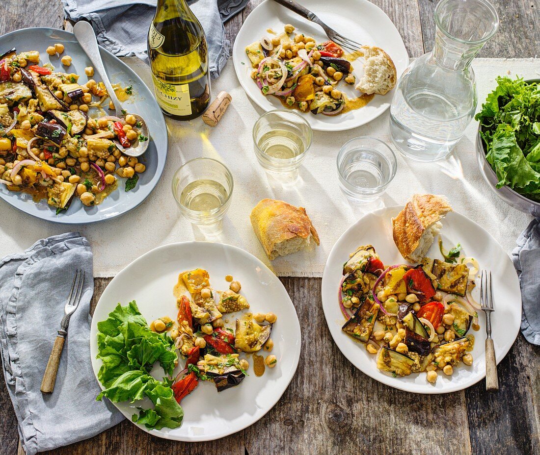 Aubergines with chickpeas and tomatoes served with baguette and white wine