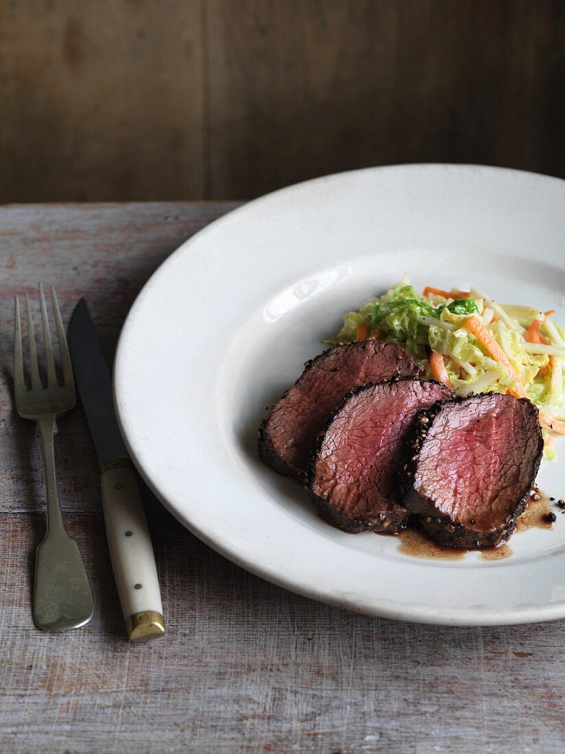 Venison fillet with a pepper crust served with a savoy cabbage and celery medley