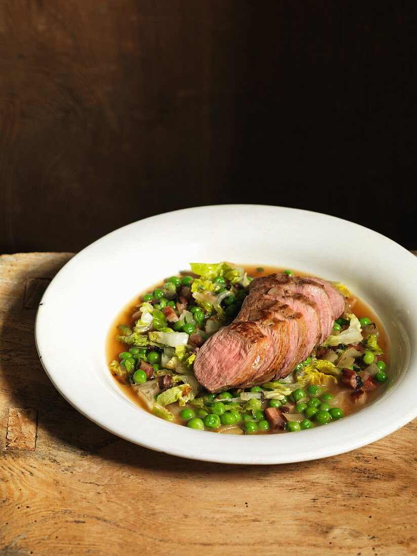 Fillet of lamb with peas, lettuce and bacon