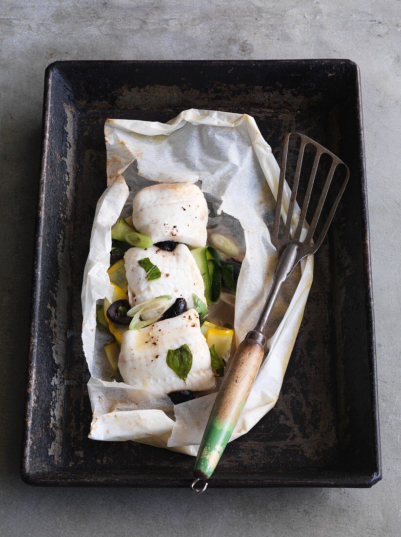 Sezungenfilet im Pergamentpapier mit Zucchini und schwarzen Oliven